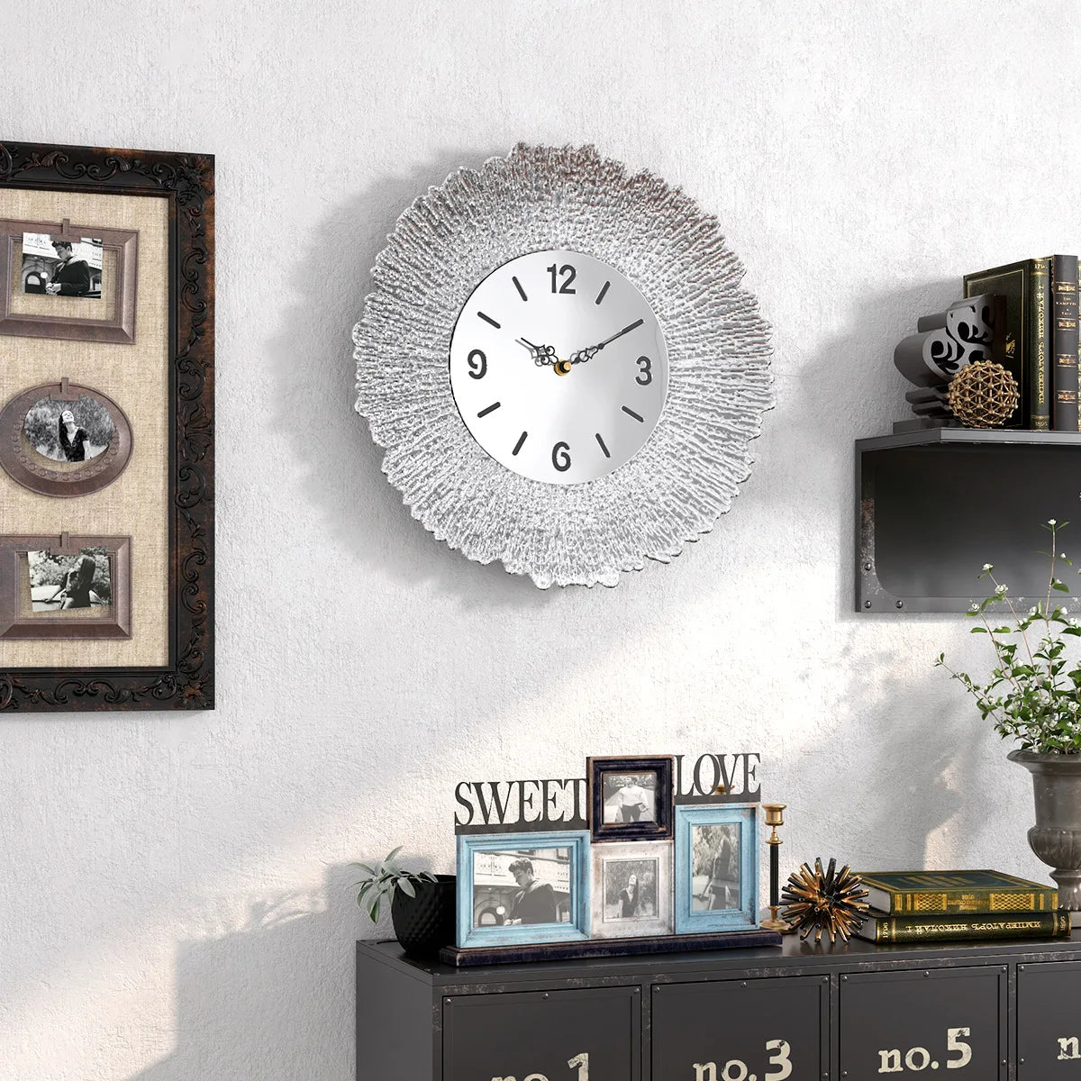 A modern silver wall clock with a textured, sunburst design hangs on a white wall.