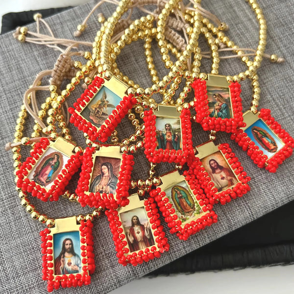 Gold-plated charm bracelet featuring red beaded charms depicting the Virgin Mary Guadalupe.