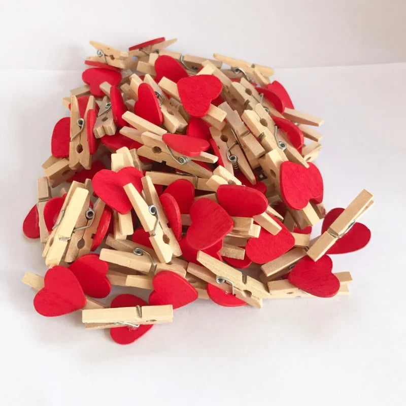 A pile of small wooden photo clips shaped like red hearts for crafts and display