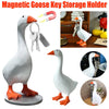 A white resin goose figurine with an orange beak and legs, shown alongside magnetic key holders.