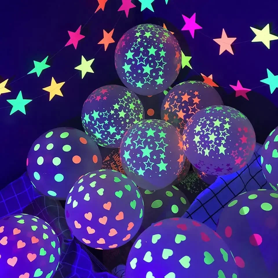 Ein Cluster leuchtender Latexballons in verschiedenen Farben und Formen vor dunklem Hintergrund.
