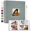 A linen scrapbook album with a gray cover and a light wood-colored pen shown alongside several photo pages.