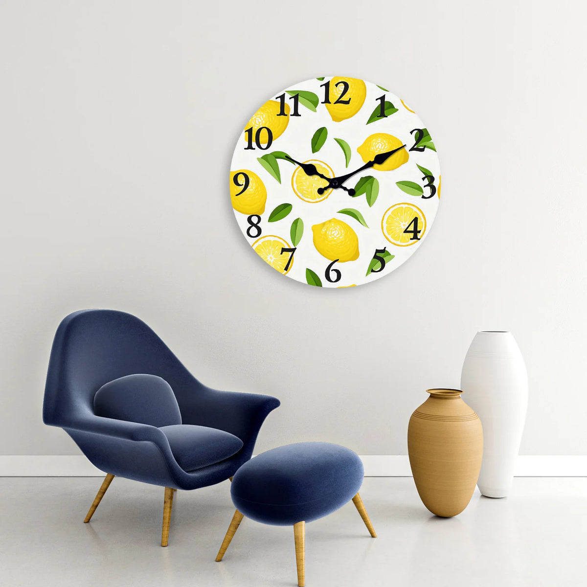 A round wall clock featuring yellow lemons and green leaves on a white background.