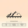 Black silhouette of a mountain range resting on a wooden shelf, used as an industrial iron wall mount key holder.