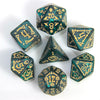 A set of seven polyhedral dice in dark green glass with gold accents arranged on a white surface.
