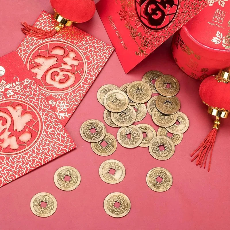 A collection of antique Chinese Feng Shui coins for wealth and good fortune displayed on pink paper.