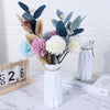Modern white plastic vase with a basket design filled with dried floral arrangements.