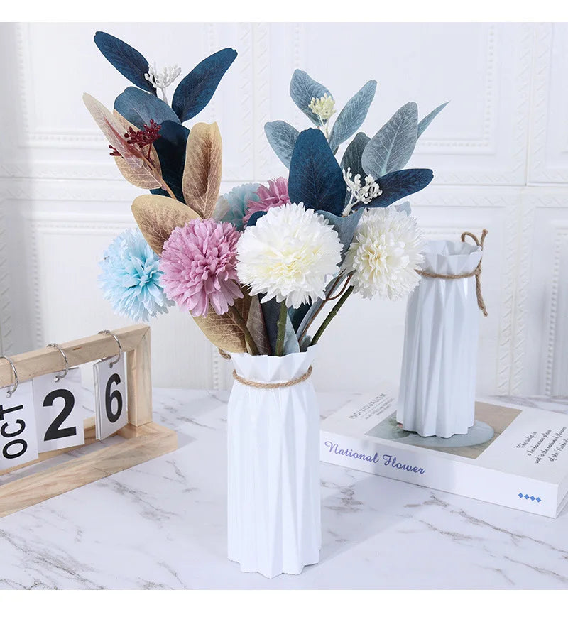 Modern white plastic vase with a basket design filled with dried floral arrangements.