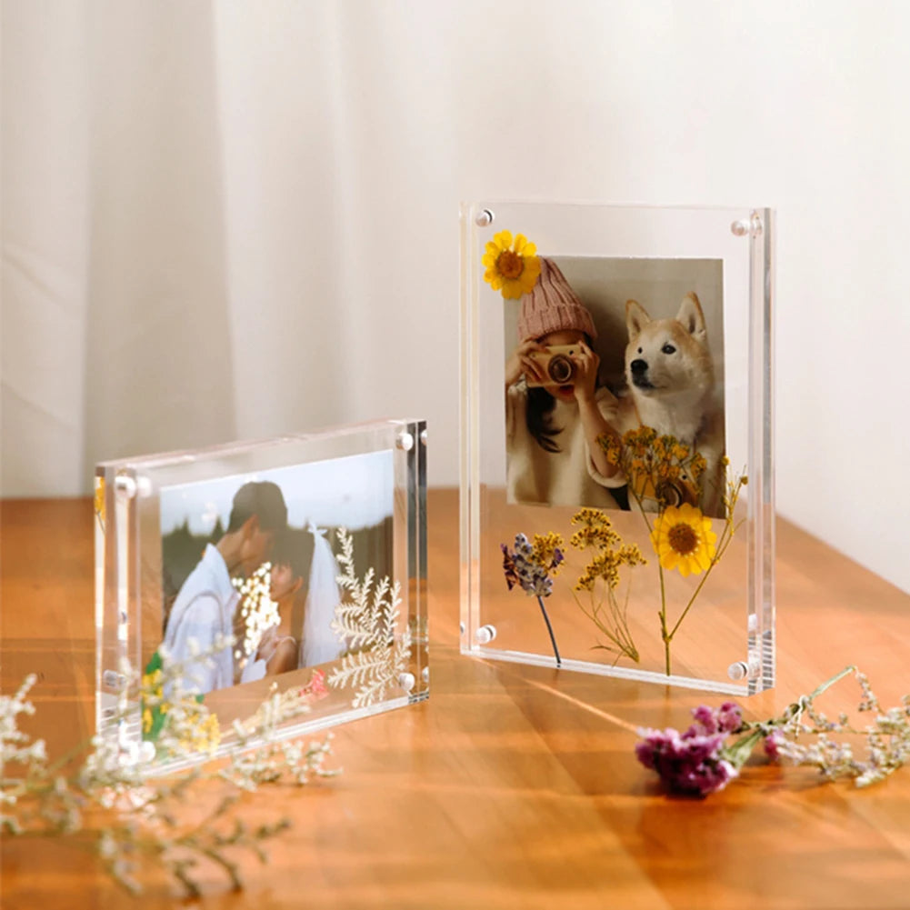 A clear acrylic magnetic photo frame displaying a portrait of a person and a dog surrounded by dried flowers.