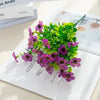 A bouquet of purple and pink silk eucalyptus and violet artificial flowers on a white background.