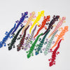 A collection of colorful 3D printed articulated gecko desk toys arranged in a line.