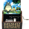 Hand-cranked wooden music box featuring a Totoro design, set in a dark wooden box.