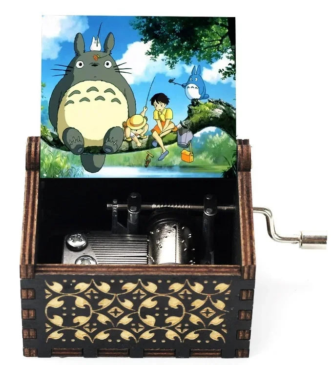 Hand-cranked wooden music box featuring a Totoro design, set in a dark wooden box.