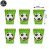 A set of six green cupcake liners with soccer ball toppers and a measuring tape.