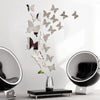 A set of twelve silver and bronze butterfly wall stickers displayed against a white wall with two black mirrors.