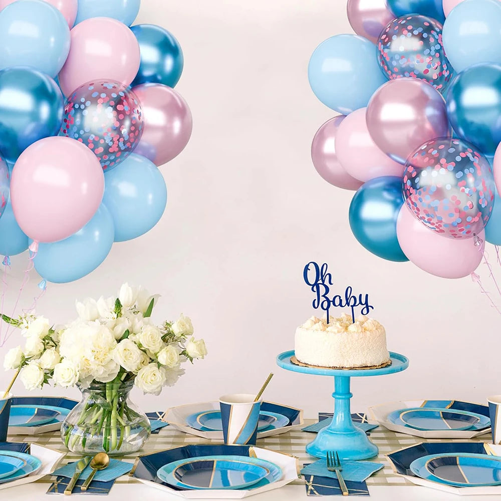 Une décoration avec des ballons roses métalliques et or rose, de la vaisselle et un arrangement floral blanc sur une table.