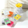 A collection of scented wax melts in various colors and scents, including lemon and vanilla, displayed next to a yellow wax m