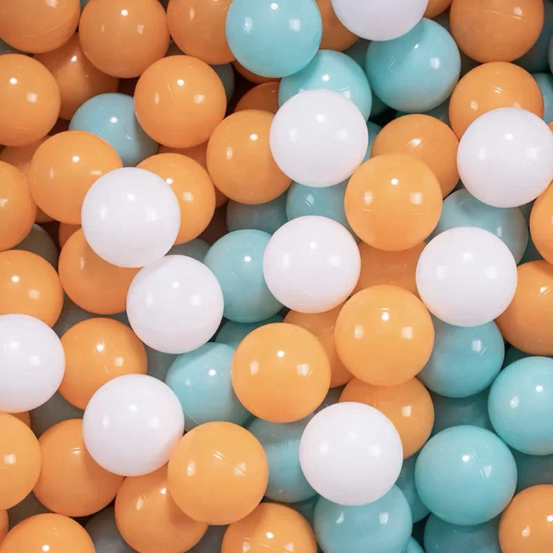 A pile of colorful, round plastic balls in shades of orange, yellow, white, and light blue.