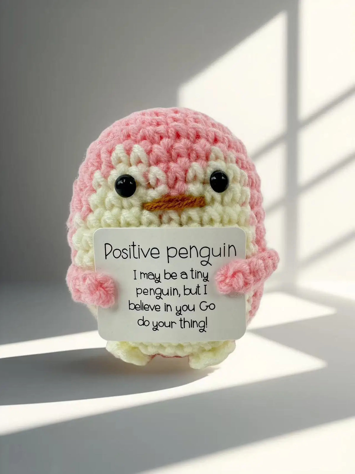Handmade crochet penguin toy with a positivity card