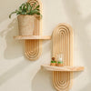 Geometric wooden wall shelves displaying a potted plant and a glass terrarium.