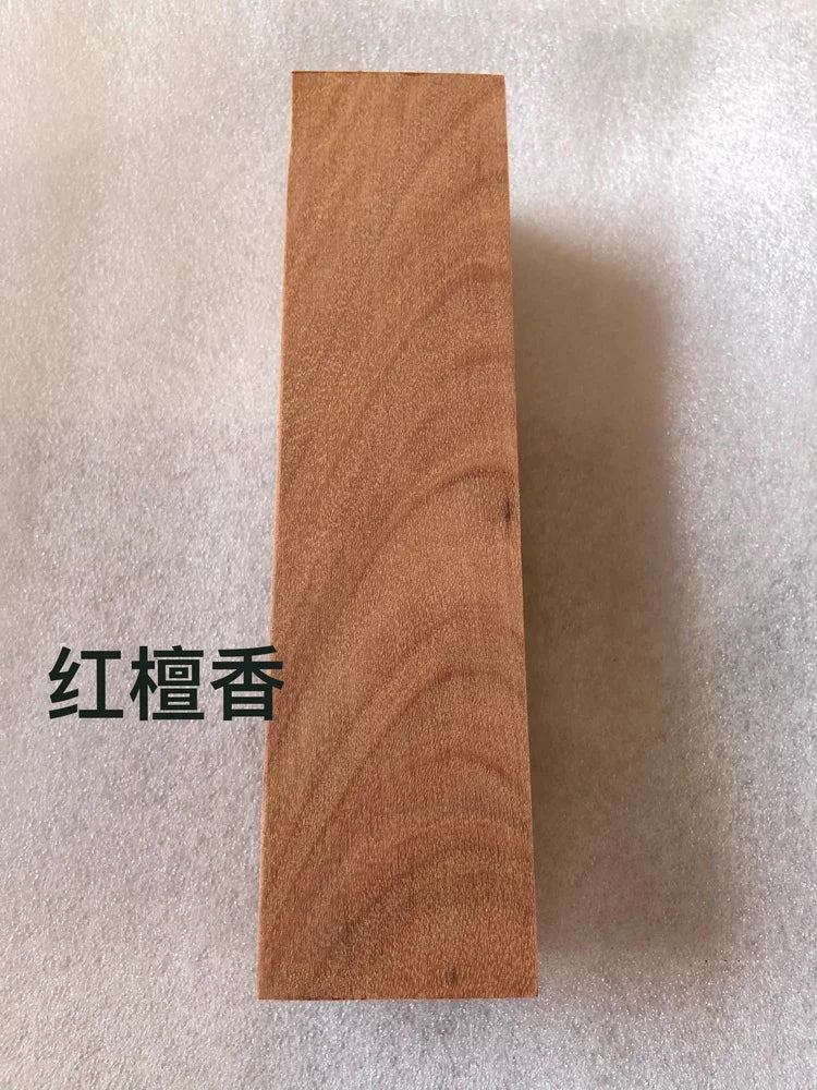 A rectangular block of reddish-brown wood, used as a blank for knife handles and DIY projects.