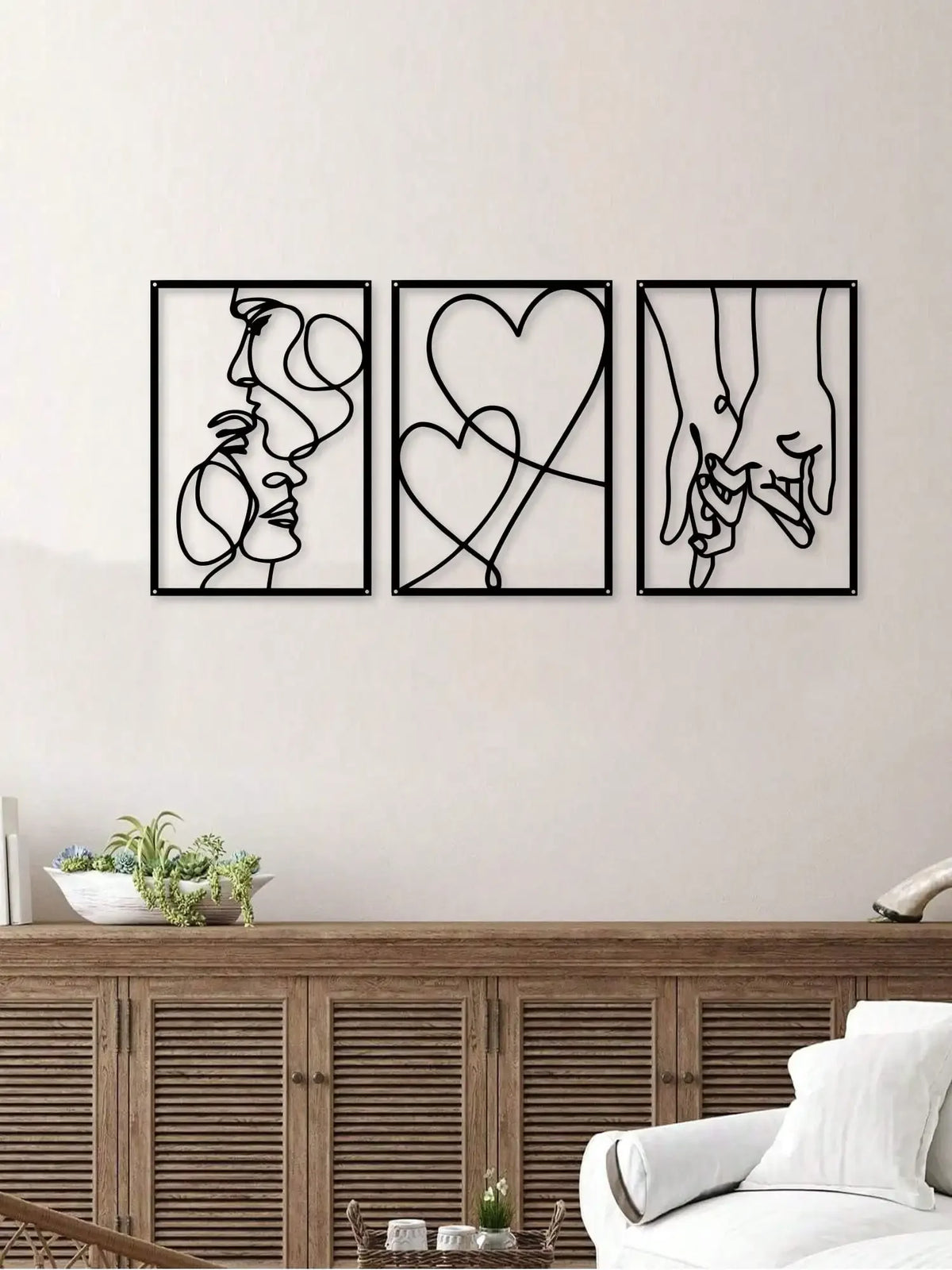 A set of three black metal line art prints depicting love and romantic motifs like a profile, a heart, and holding hands.