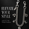 Collier en chaîne argentée avec divers charms : une étiquette, des sphères, une fleur, une étoile et un pendentif en forme de