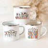 A white enamel mug with a floral design featuring the text TEACHER and surrounding flowers.