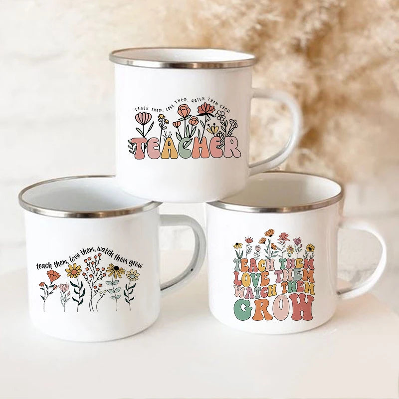 A white enamel mug with a floral design featuring the text TEACHER and surrounding flowers.