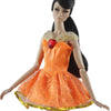 A handmade doll dress gown in bright orange with gold glitter detailing and a red jewel embellishment.