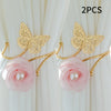 A set of two gold-toned decorative flower butterfly curtain tiebacks with pink roses and pearl accents.