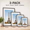 A set of three framed prints featuring the Eiffel Tower in black and white tones displayed on a wooden surface.
