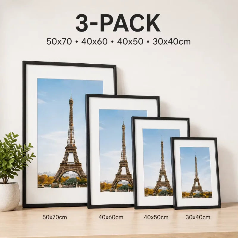 A set of three framed prints featuring the Eiffel Tower in black and white tones displayed on a wooden surface.