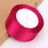 Roll of vibrant pink satin ribbon with white fluffy material for crafts and gift wrapping