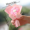 A pink handmade crochet flower bouquet with a white center is held in a hand.