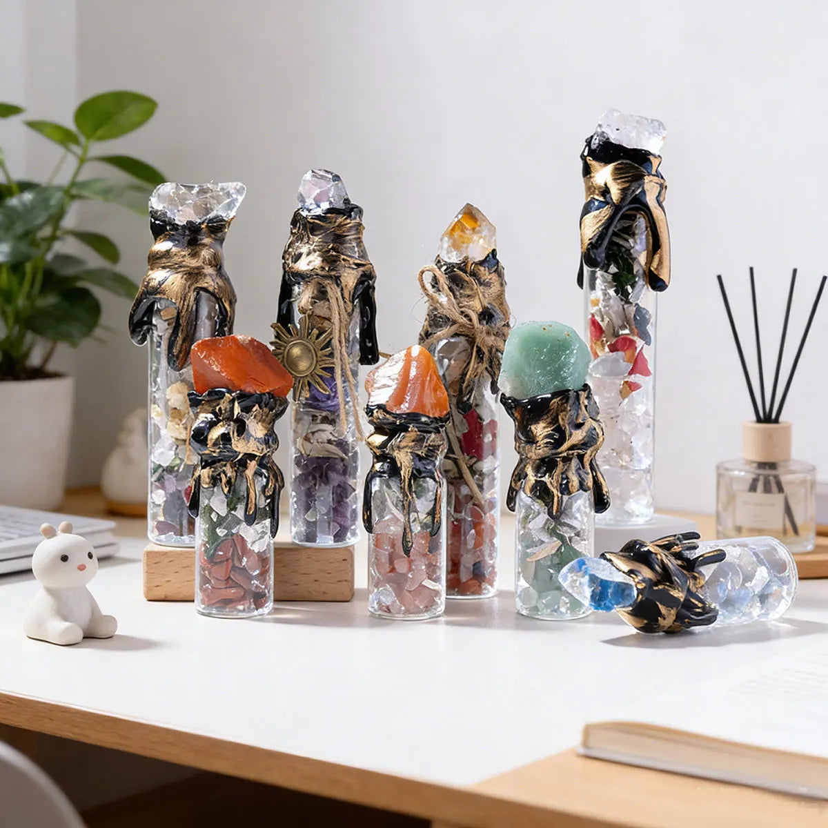 A collection of natural crystal wishing bottles filled with various raw stones and featuring gold-colored metal accents.