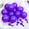 A cluster of purple latex balloons scattered on white sheer fabric.