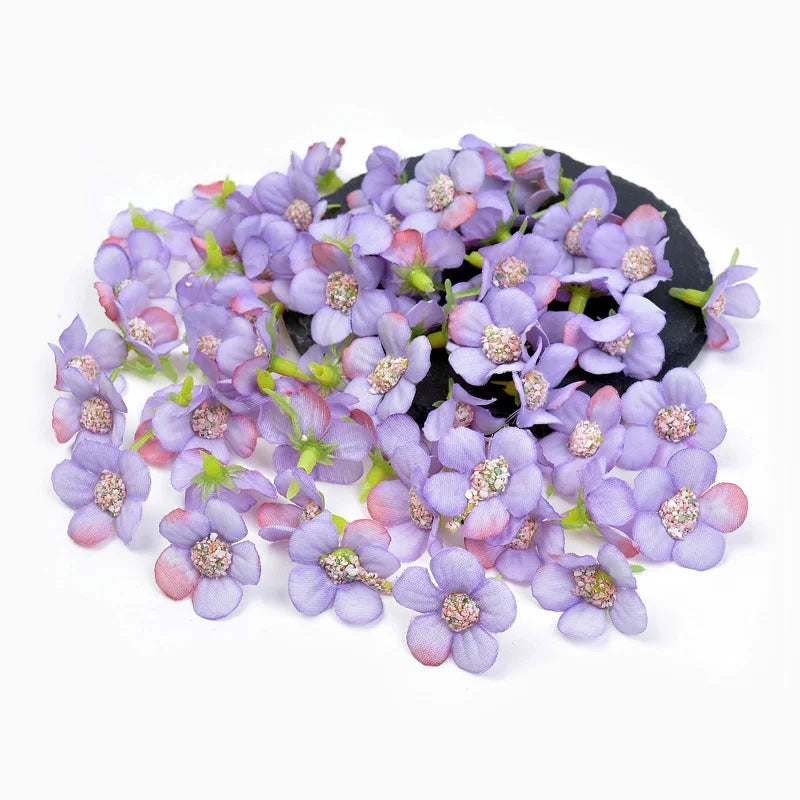 A cluster of small purple and pink silk artificial flower heads on a dark background.