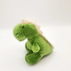 A soft green plush animal with white accents, likely a fridge magnet.
