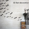 A white brick wall decorated with black bat silhouettes in flight for Halloween theme