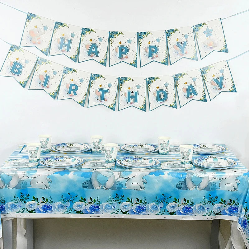 A decorative banner featuring blue and white elephants and the words Happy Birthday strung across a white wall.