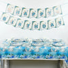 A decorative banner featuring blue and white elephants and the words Happy Birthday strung across a white wall.