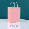 Pink paper gift bag with white handles, measuring 15x8x21 cm.