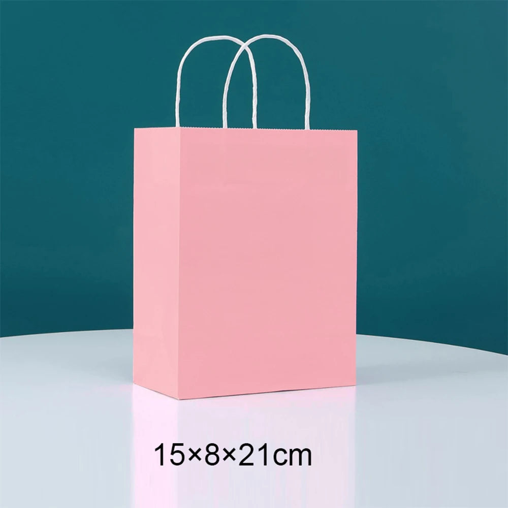 Pink paper gift bag with white handles, measuring 15x8x21 cm.