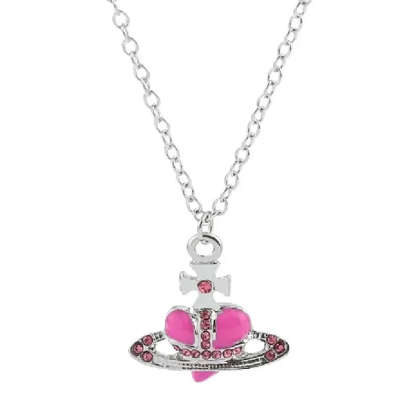 Silver pendant necklace featuring a cross and a pink heart charm with small pink stones