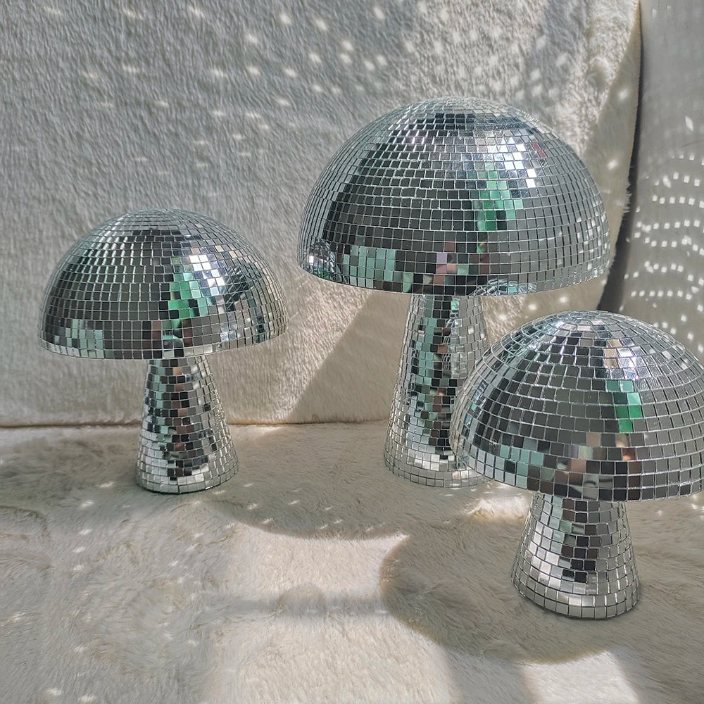 Silver mosaic mushroom disco ball decoration resting on a light-colored surface.