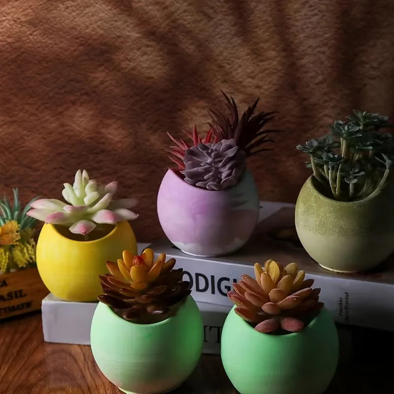 A collection of silicone arc candle jars in various shades of pink, yellow, and green resting on a wooden surface.