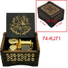 A wooden music box with a lid featuring an ornate design and a golden mechanism inside.