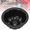 A black nonstick mini fluted cake pan is shown against a blurred red background.