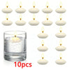 A set of ten white unscented floating candles displayed next to a glass of water.